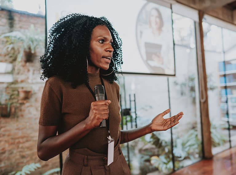 Black lady presenting to her team in the workplace